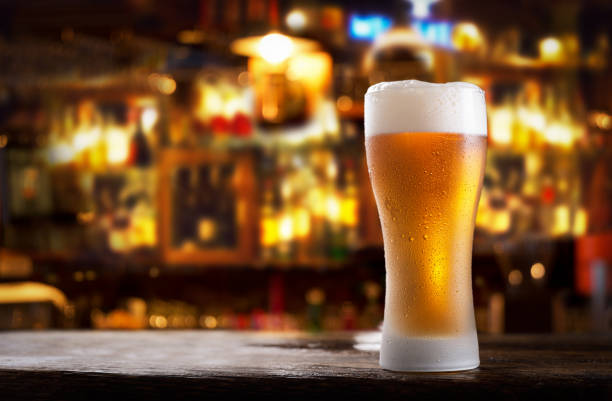 cold glass of beer in a bar on a wooden table stock photo