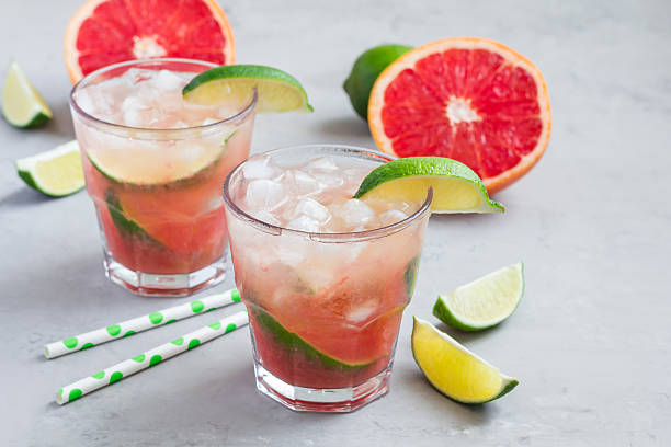 Cold pink cocktail with fresh grapefruit, lime, copy space stock photo