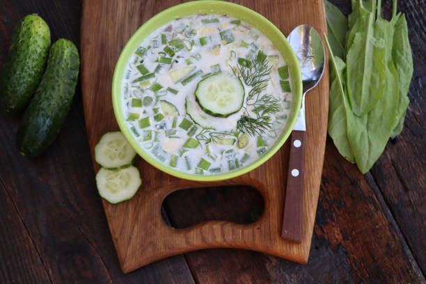 Cold soup with cucumbers, yogurt, sorrel and fresh herbs on the wooden rustic table stock photo