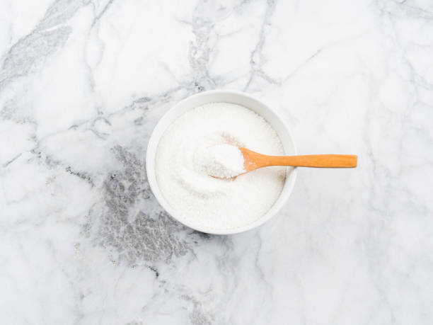 Collagen protein powder in bowl on marble Collagen protein powder in bowl with wooden spoon on marble table. Top view food additive stock pictures, royalty-free photos & images