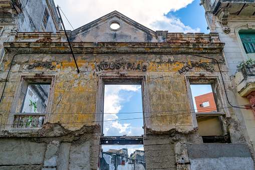 Havana, Cuba - May 10, 2022: Low angle view of a collapsed building. Only the old facade is left.  The scene is common in the Communist-run island.