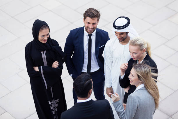 Colleagues outside of their office having a conversation Corporate Business In The Middle East abaya clothing stock pictures, royalty-free photos & images