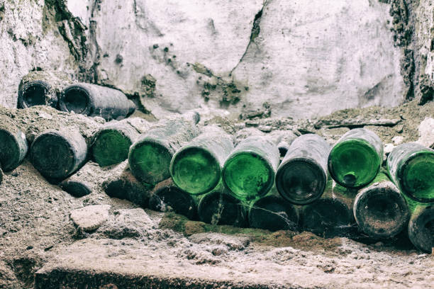 Collectible exclusive wine  in a cobweb in the cellar. Old dusty wine bottles covered in mold in vintage wine cellar. stock photo