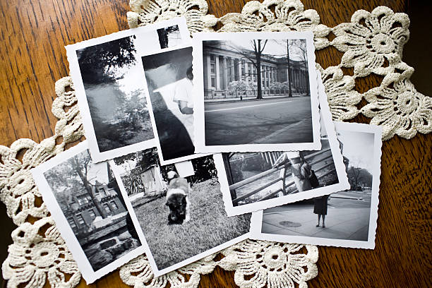 Collection of Old black and white Photographs Collection of old vintage black and white photographs on a table showing the idea of nostalgia, time, memories and the past stack photos stock pictures, royalty-free photos & images