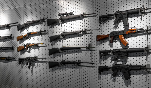 Collection of rifles and carbines. Various firearms hang on special mounts on the wall. Weapon background. stock photo