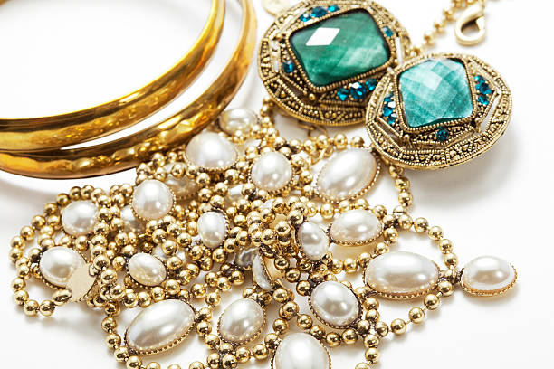 collection of vintage jewelry on white surface - juwelen stockfoto's en -beelden