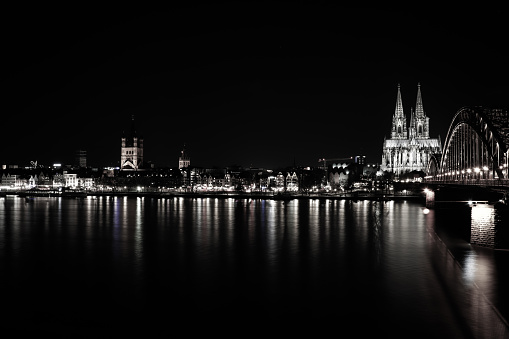 The illuminated Cologne Cathedral and Hohenzollern Bridge. Long exposure at night.
