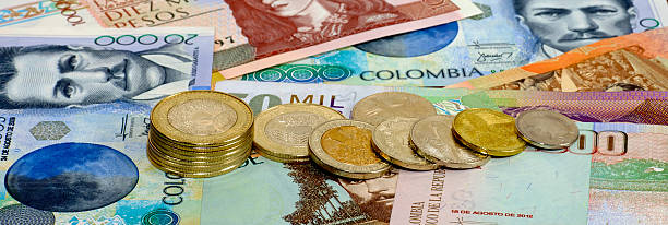 Colombia – Photograph Of Banknotes and Coins From The Country Arranged With Coins Tipping Over And Finished As A Banner Style Image stock photo