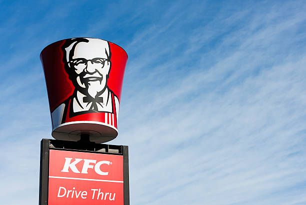 Colonel Sanders' image on bucket-shaped sign above KFC franchise stock photo