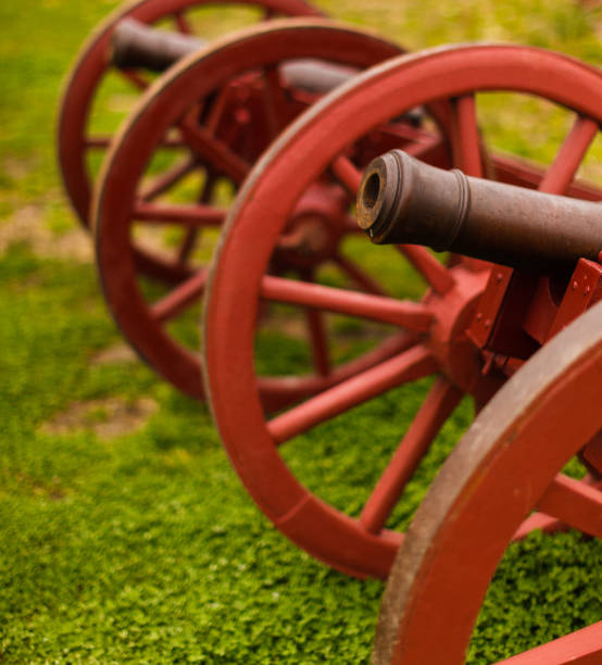 colonial style cannons "colonial style cannons over grass on williamsburg, virgnia - usa" williamsburg virginia stock pictures, royalty-free photos & images