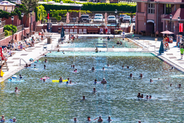 Colorado natural hot springs pool in downtown with water and people swimming Glenwood Springs, USA - July 10, 2019: High angle view of famous Colorado natural hot springs pool in downtown with water and people swimming garfield county utah stock pictures, royalty-free photos & images