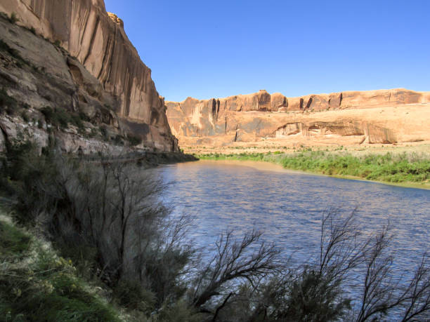 Colorado river just outside Moab The Colorado River flowing between high reddish colored sandstone cliffs in Castle Valley, just outside of Moab in the USA. entrada sandstone stock pictures, royalty-free photos & images