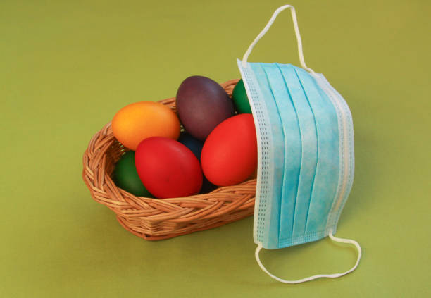 Colored eggs in basket medical mask Easter 2020 stock photo