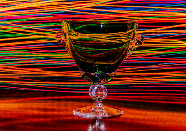 Colored lights behind a clear glass goblet. stock photo