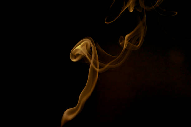 Colored smoke on black background. Yellow color. stock photo