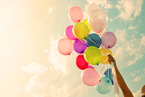 Colorful balloon Girl hand holding colorful balloons. happy birthday party. vintage filter effect moving up photos stock pictures, royalty-free photos & images
