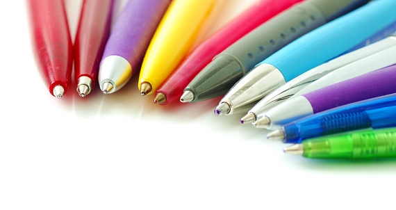Many colorful ballpoint pens in a row