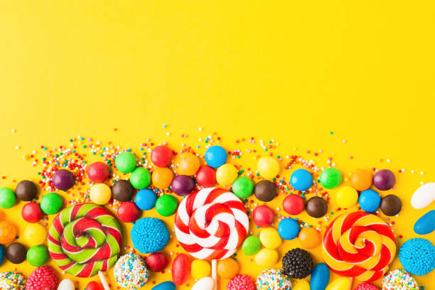 Colorful candies over yellow background. Top view. Flat lay Colorful candies over yellow background. Top view. Flat lay. Copy space. Sweet mix for birthday or candy shop candy jar stock pictures, royalty-free photos & images