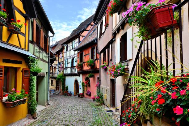 Colorful cobblestone lane, Eguisheim, Alsace, France Quaint colorful cobblestone lane in the Alsatian town of Eguisheim, France colmar stock pictures, royalty-free photos & images