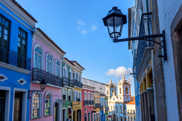 Colorful colonial-style houses and a tower of an old baroque church in Pelourinho Old facades of colorful colonial-style houses and a tower of an old baroque church in Pelourinho, the famous historic center of Salvador, Bahia pelourinho stock pictures, royalty-free photos & images
