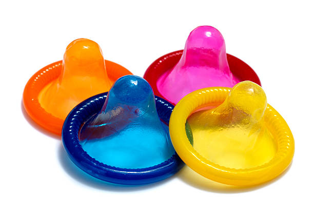 Colorful condoms in Orange, pink, blue, and yellow stock photo