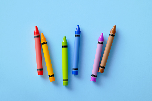 Colorful crayons on blue background. Horizontal composition with copy space.