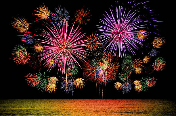 Colorful firework celebration on dark night sky background. stock photo