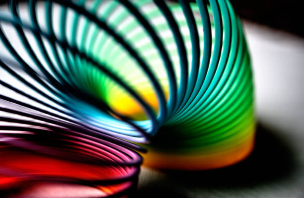 kleurrijke flexibele bouncy plastic lente die in een boog wordt gebogen - flexibiliteit stockfoto's en -beelden