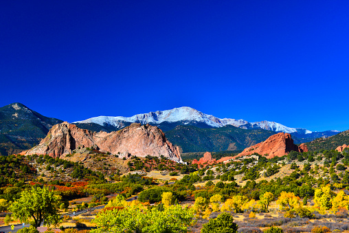 Snow capped Pikes Peak soaring over the Garden of the Gods Park in Colorado Springs, Colorado in a colorful Autumn morning. The photo was taken at the Garden of the Gods Visitor Center with my Nikon D800E.