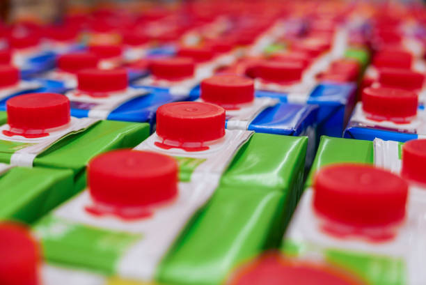 caixas de suco coloridas com tampa de rosca vermelha na prateleira do supermercado. - caixa de leite - fotografias e filmes do acervo