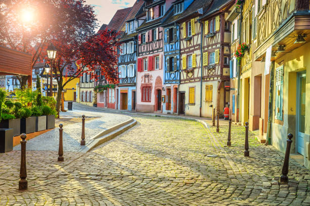 Colorful medieval half-timbered facades with paved road in Colmar stock photo