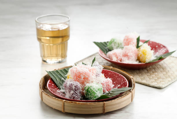 Colorful Ongol-Ongol or Sentiling, Steamed Cassava Cake Coating with Grated Coconut, Served on Ceramic Plate. stock photo