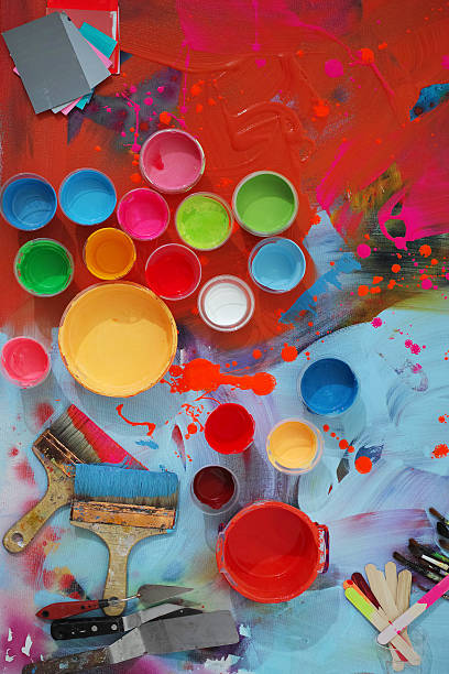 Colorful Painted Canvas With Brushes and Paint Cans stock photo