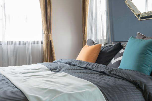 coloridas almohadas de cama de color oscuro en dormitorio moderno - foto de stock