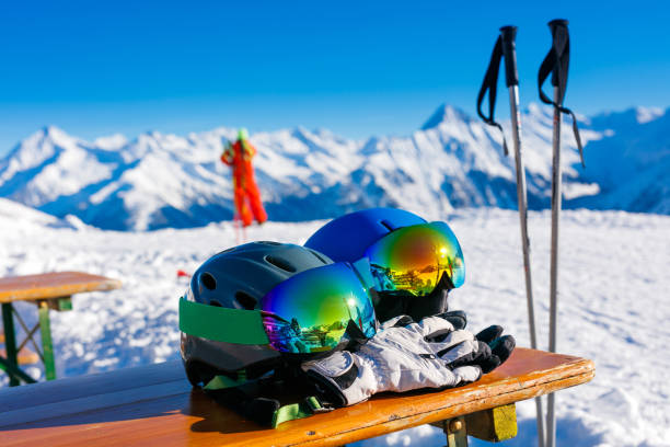 Colorful ski glasses, gloves and helmet on wooden table. stock photo