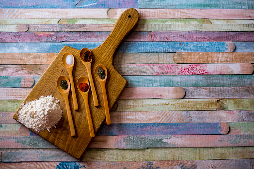 Colorful spices in wooden spoons - beautiful kitchen image.