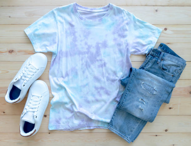 Colorful tie die tshirt, jean and shoes on wooden background. fashion summer stock photo