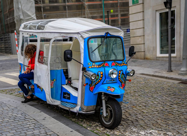 colorful tuktuk on a typical cobbled street in the old town city center waiting for tourists in porto, portugal - carro oporto imagens e fotografias de stock