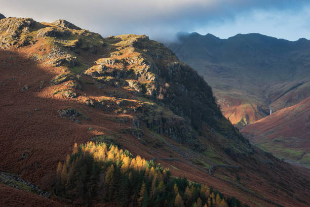 Colorful vibrant Autumn landscape image looking from Pike O'Blisco towards Langdale Pikes and Range with beautiful sungiht on mountains and valley stock photo