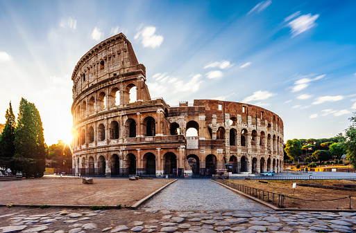 Colosseum in Rome during sunrise. Italy travel destination. Long exposure image with moving clouds.