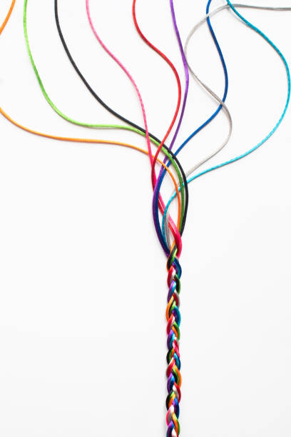 gekleurde string die in elkaar geweven is om concepten van eenheidsmaatschappij saamhorigheid en samenwerking te illustreren - garen naaigerei stockfoto's en -beelden