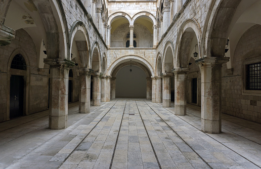 A Gothic looking chamber with columns, arches and a long entrance hallway.  Main focus on central hallway.
