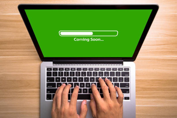 Coming soon Concept Laptop Screen With Typing Hands On Keyboard stock photo