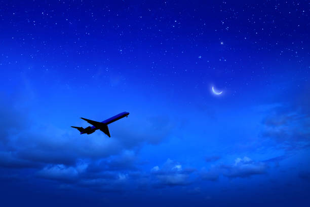 Commercial airplane flying at night sky stock photo