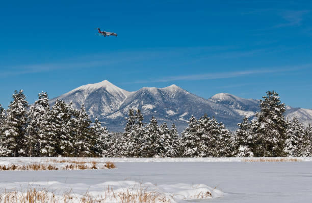 Commercial Jet Approaching the Airport This commercial jet is passing by the snow covered San Francisco Peaks as it approaches the airport in Flagstaff, Arizona, USA. jeff goulden flagstaff stock pictures, royalty-free photos & images