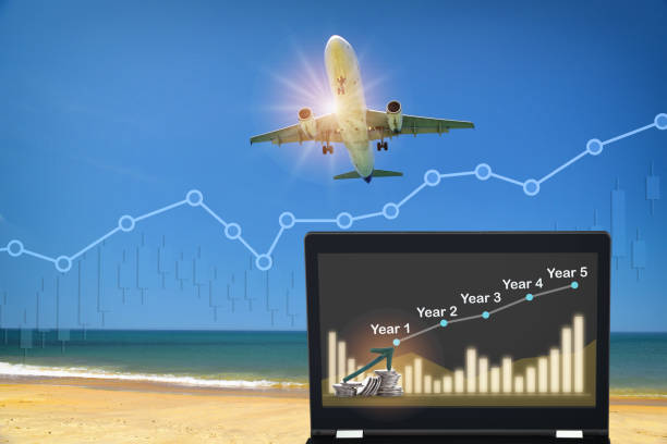 Commercial plane ready for landing or taking off with growth graph on computer notebook stock photo