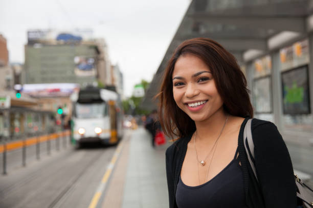 Commuter Waiting for the Tram Female commuter waiting for the tram in downtown Melbourne, Australia. filipino ethnicity stock pictures, royalty-free photos & images