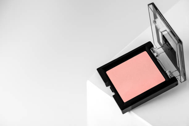 Compact pink blush on a geometric gray background close-up. Makeup beauty is a mineral product with a powdery texture. Concealer in an open black container on the podium. Compact pink blush on a geometric gray background close-up. Makeup beauty is a mineral product with a powdery texture. Concealer in an open black container on the podium cosmetic packaging stock pictures, royalty-free photos & images