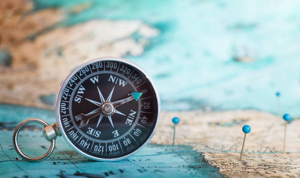 kompass auf der karte - karte navigationsinstrument fotos stock-fotos und bilder