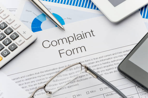Complaint form on a desk. Complaint form on a desk. Complaint form on a desk with a calculator, pen, glasses, mobile phone and digital tablet. complaining stock pictures, royalty-free photos & images